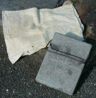  An old footstone with its felt cover to keep our feet warm in bed in the winter. It was heated in a fireplace, then placed at the foot of a bed to keep it warm during winter. 