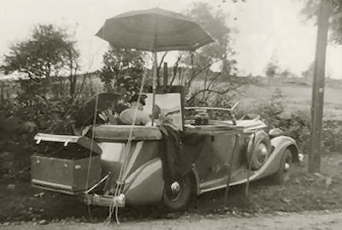Woodward in his 1936 Packard, along the side of the road painting